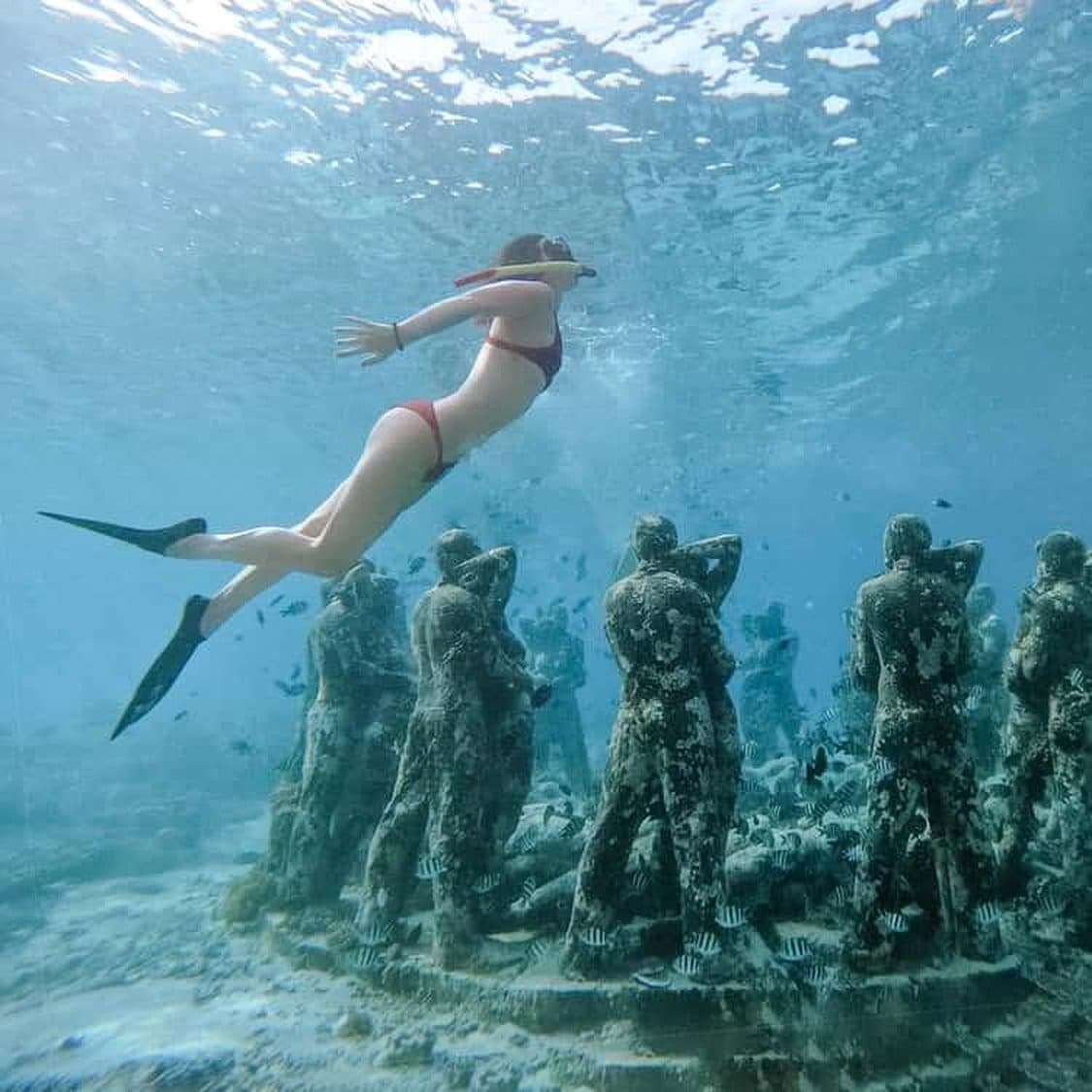 Snorkeler above the underwater statues at Gili Meno
