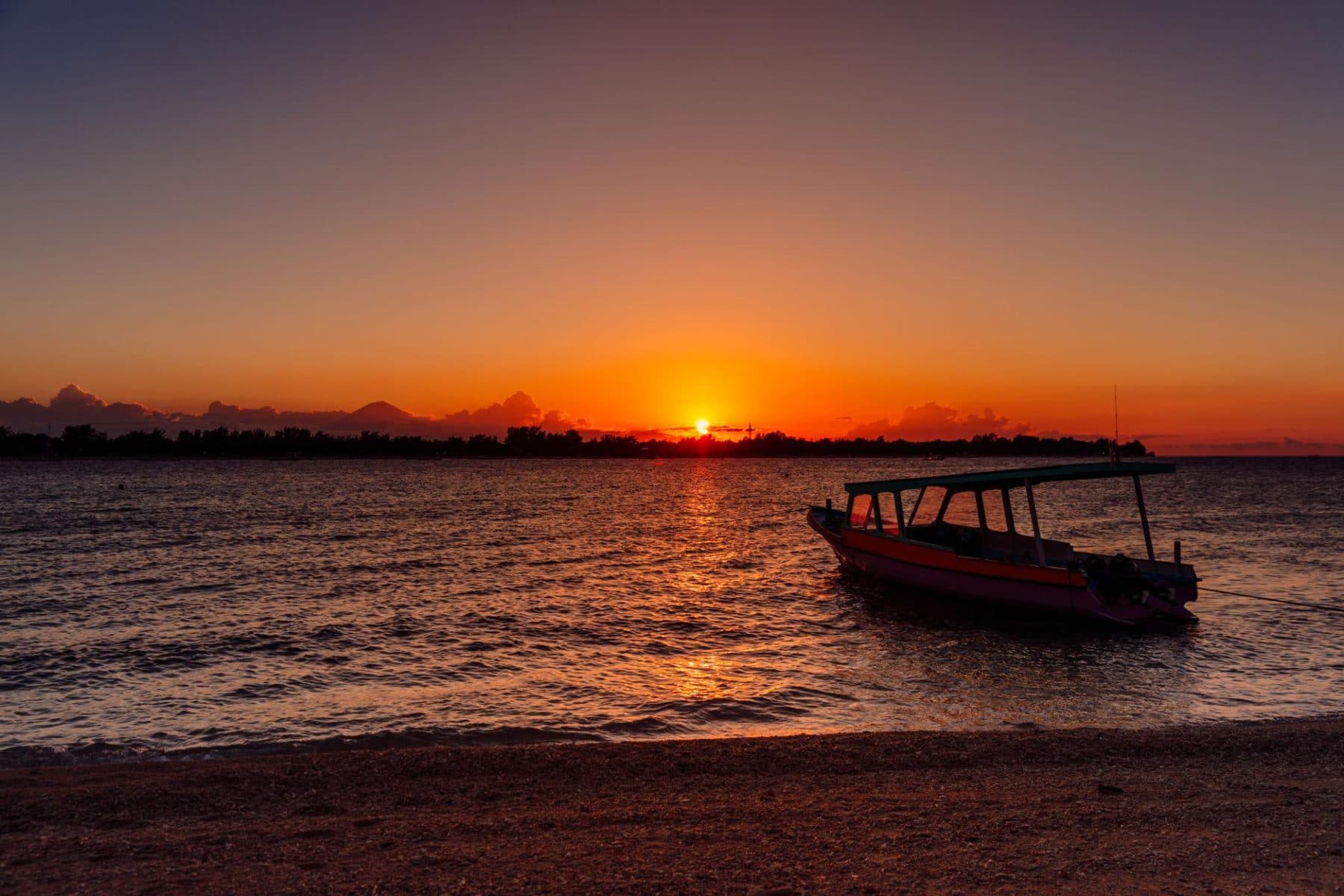 Traditional boat at sunset off a Gili beach