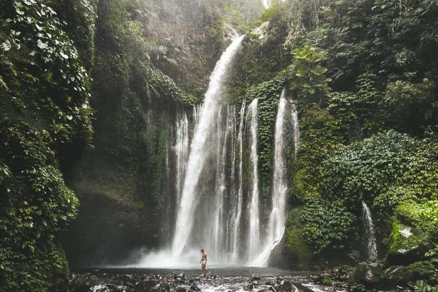 A traveler standing at the base of Tiu Kelep