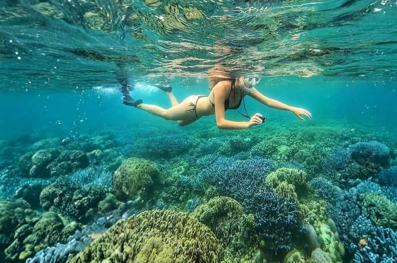Snorkeling over coral reefs around Gili Asahan