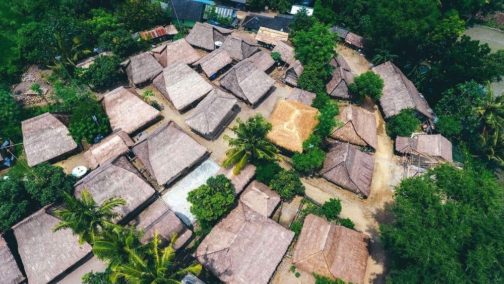 Aerial view of Sade’s cluster of thatched Sasak houses among palms