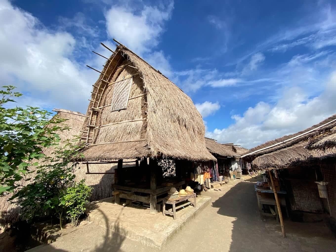 A lumbung rice barn on the village street in Sade under blue sky