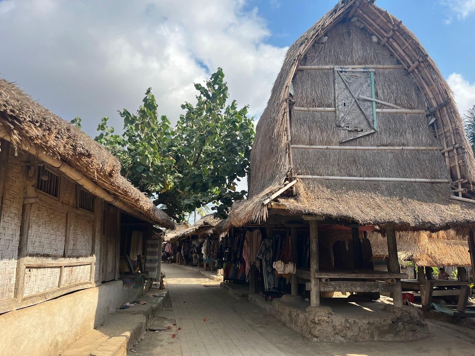 A village path in Sade between traditional houses and a thatched Sasak rice barn