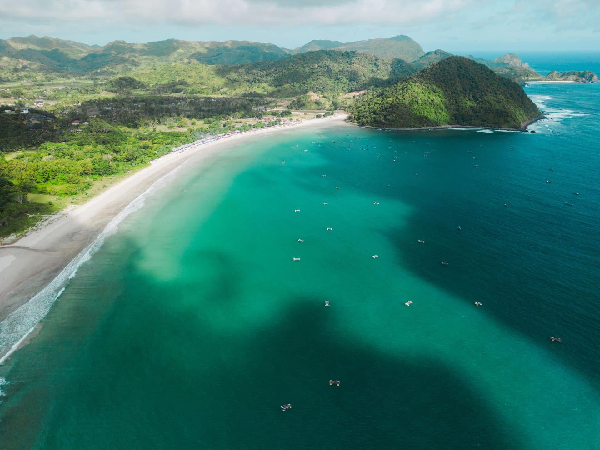 Aerial of Selong Belanak with boats in the bay