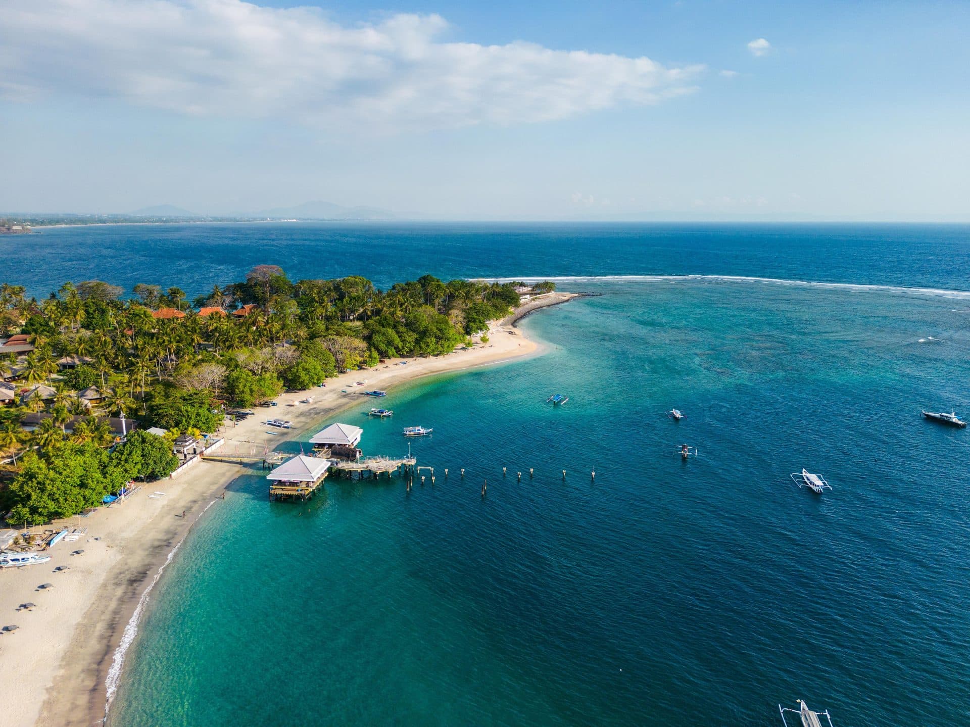 Aerial view of Senggigi’s west-coast shoreline, jetties, and turquoise water