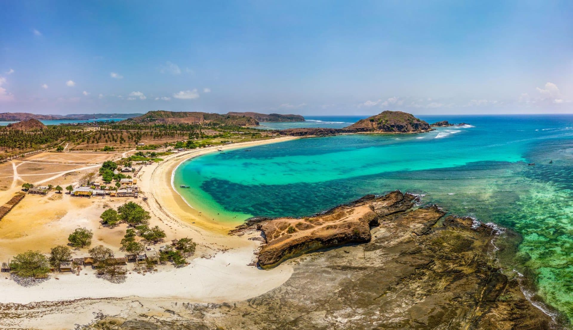Rocky reef, white sand, and turquoise water at Tanjung Aan