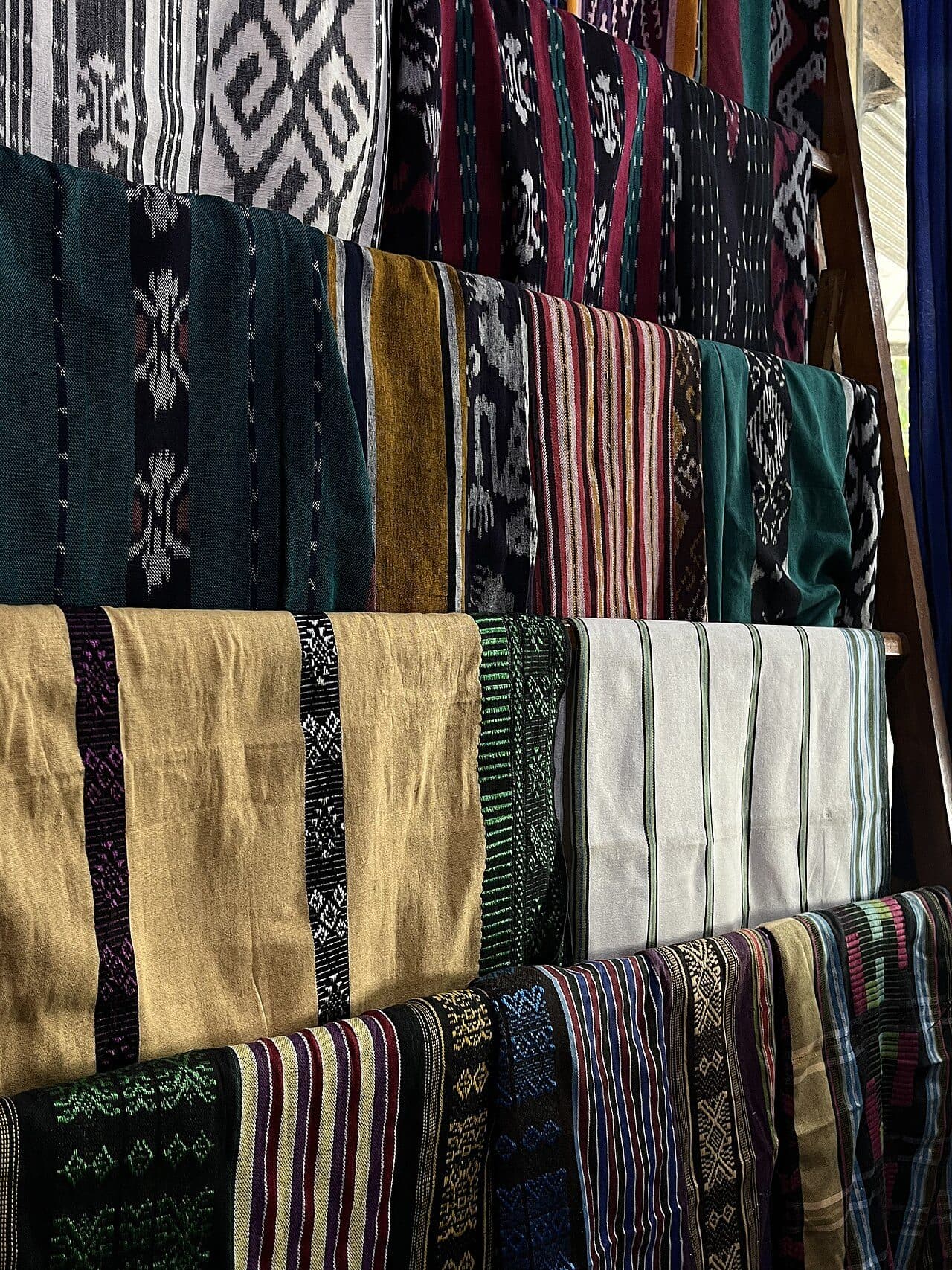 Folded handwoven Sasak fabrics in a village workshop