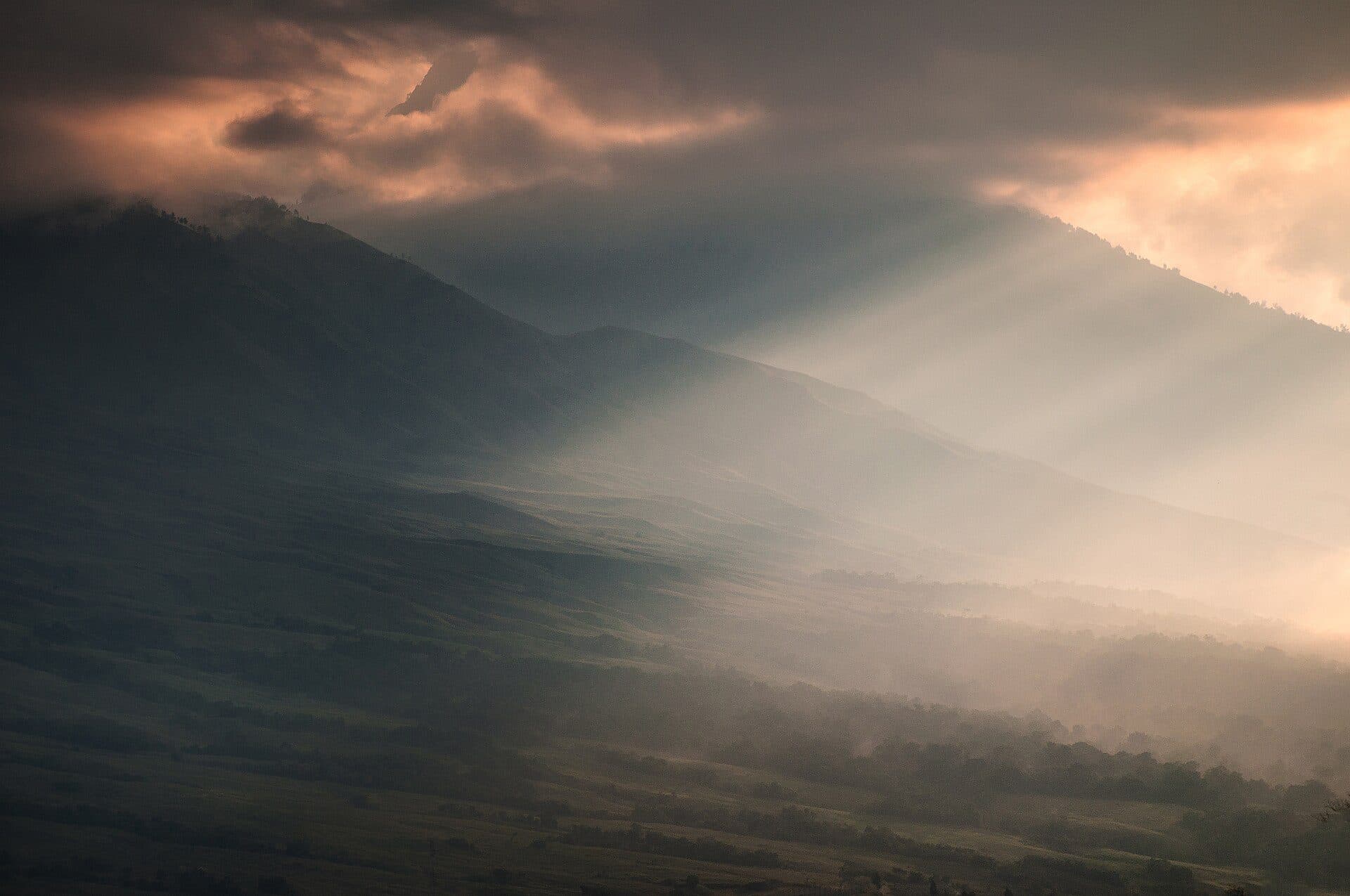 Sunbeams over the green hills around Sembalun